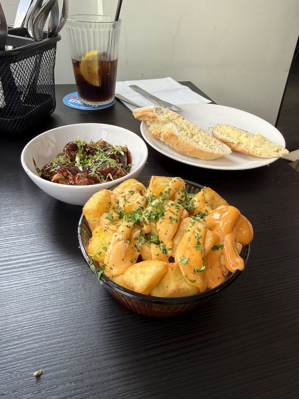 Fried potatoes with an orange sauce, plus bread and a small dish