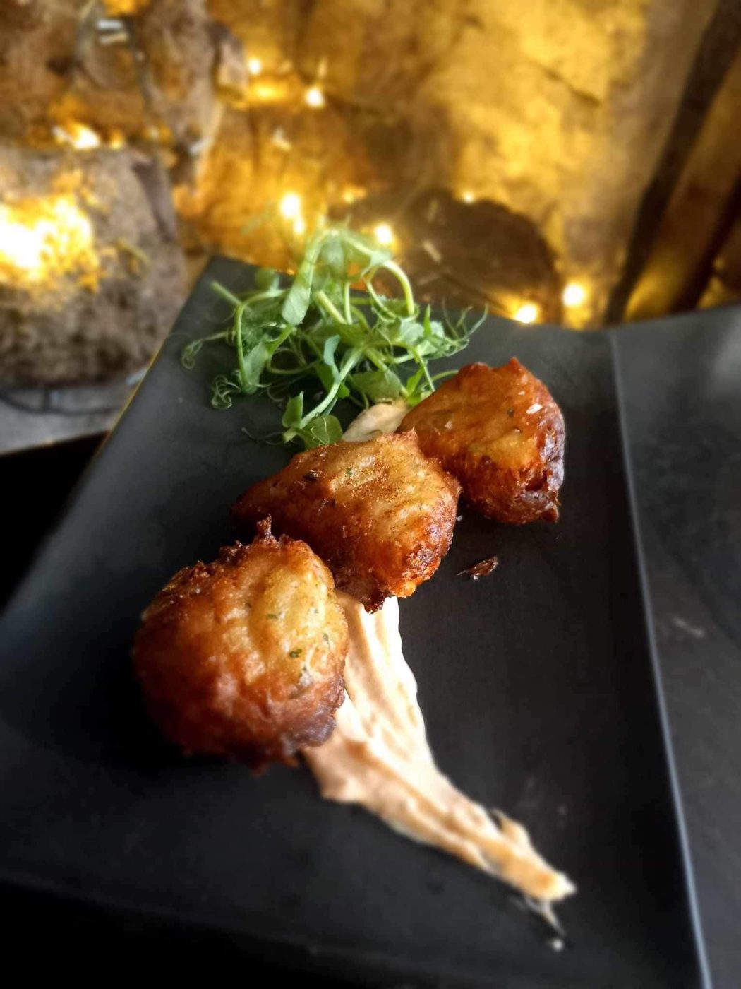 Fried croquettes with leaves on a slate