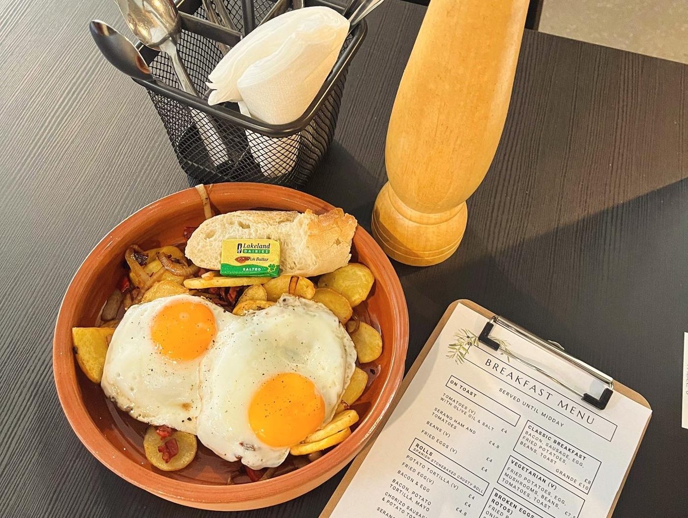 Fried eggs over potatoes in a terracotta dish